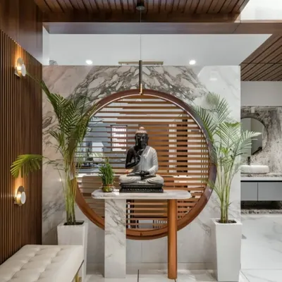 This serene foyer design features a Buddha statue as the focal point, set against a backdrop of marble and wood slats. The design creates a peaceful and welcoming entry into the home.