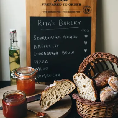 A rustic bakery scene, complete with a menu board, fresh sourdough, and homemade jams. This image tells a story of a small, artisanal bakery and the love that goes into its products.