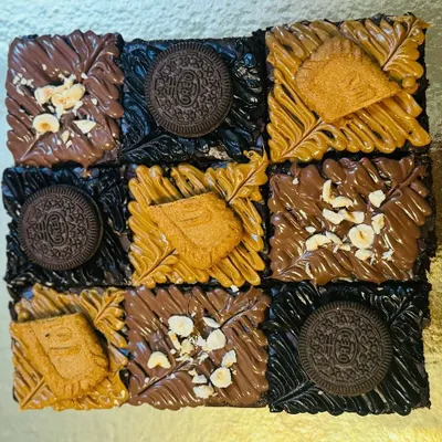 This top-down view shows the beautiful details of my nine-piece assorted brownie slab. You can see the different textures from the crunchy Oreo, smooth Biscoff spread, and chopped hazelnuts on a rich Nutella base.