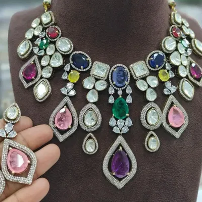 A stunning multi-color necklace set perfect for a sangeet or reception. This rental piece features a mix of colorful stones and uncut Polki, making it a vibrant and eye-catching choice.