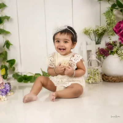 That smile is pure magic. This sitter session, with a simple and elegant floral background, is all about capturing your baby's happy personality.