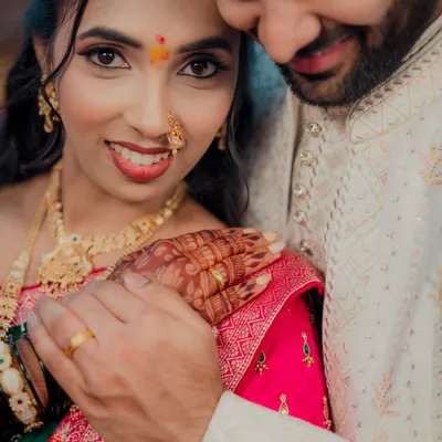 An intimate close-up of a beautiful Maharashtrian bride on her engagement day. Her expressive eyes, traditional nath, and the gentle touch of her partner create a powerful portrait.