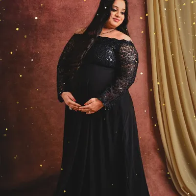 A classic solo portrait featuring one of our black off-shoulder lace gowns. The warm lighting and subtle sparkle effect add a touch of magic to the image.