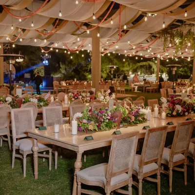 An evening to remember forever. This tablescape features lush floral runners, glowing candles, and elegant place cards, creating a romantic and intimate atmosphere for a reception dinner.