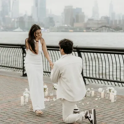 The plan in motion. With candles and the city waiting, Monil gets down on one knee. My job here is to be invisible, capturing the surprise proposal as it unfolds naturally.
