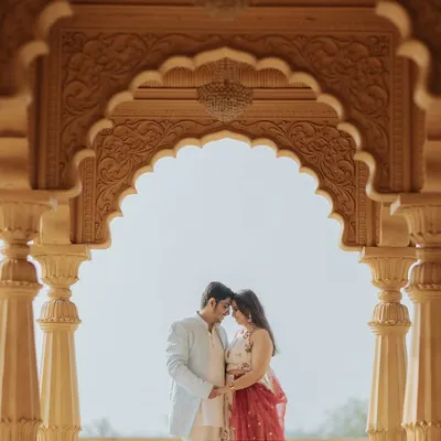 An intimate moment framed perfectly by the intricate arches of a palace. This composition uses architecture to create a naturally beautiful and romantic portrait.