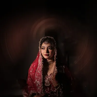 A moment of quiet contemplation. I used dramatic lighting to create this artistic bridal portrait, highlighting her stunning features and the richness of her red lehenga.