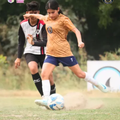 An action shot capturing the raw power of our player striking the ball, kicking up a cloud of dust. This image shows the fierce determination we bring to every single match.