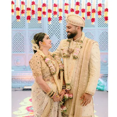 A beautiful, candid moment between the bride and groom, Diana and Pavan. Her custom gold-embroidered blouse and his elegant sherwani were designed to create a harmonious look.