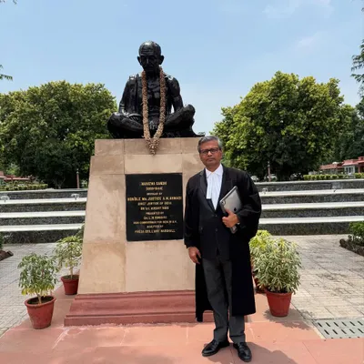 After seventeen years of practice, standing before the statue of Mahatma Gandhi on the Supreme Court premises, a place that symbolizes the pursuit of justice.