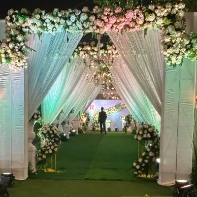 An entrance that whispers elegance. I designed this walkway with flowing white drapes and lush floral arches, leading guests into a serene and magical reception space.
