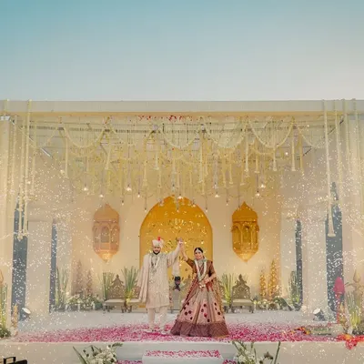 A mandap straight out of a fairytale. I combined a backdrop of traditional Rajasthani arches with modern elements like cascading floral strings and dramatic cold pyro sparklers for a truly cinematic varmala moment.
