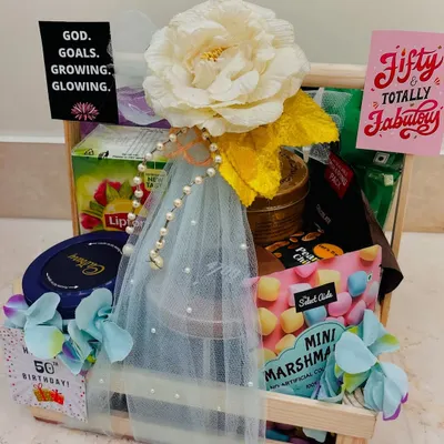Celebrating a golden milestone. We curated this "Fifty & Totally Fabulous" hamper for a 50th birthday, filling a wooden crate with tea, chocolates, marshmallows, and other delightful treats.