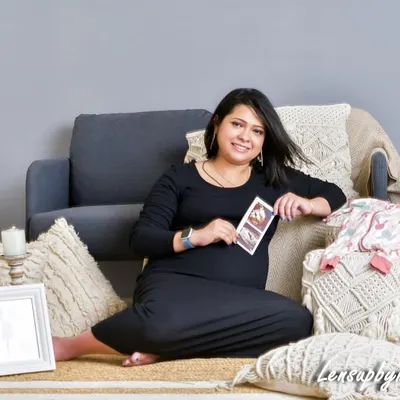 A cozy, boho-themed setup right in my studio. The mother-to-be holds her ultrasound photo, surrounded by soft textures, candles, and a framed picture, creating a warm and personalized scene.