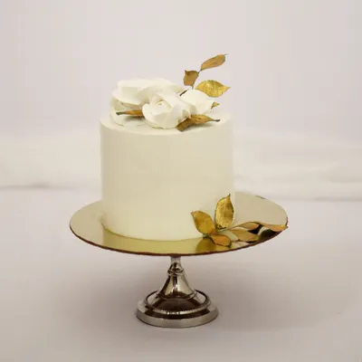 Sometimes, the simplest designs are the most elegant. This minimalist cake features a smooth white finish, accented with delicate white chocolate roses and hand-painted gold leaves. It’s a perfect centerpiece for an intimate wedding, engagement, or a special anniversary.
