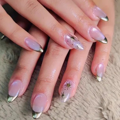 A celestial take on a classic French. These nails feature a sheer nude base with metallic gold tips, accented with delicate, hand-painted gold stars for a touch of magic.