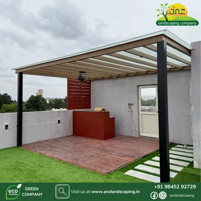 A modern pergola installation at a villa in Assetz Soul & Soil, Bangalore. This design features a powder-coated MS frame, toughened glass roofing, and a wood-finish deck with a bar counter.