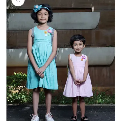 Here you can see how my crochet flower patches look on children's dresses. The patches add a charming, handmade detail to simple outfits, making them unique and special.