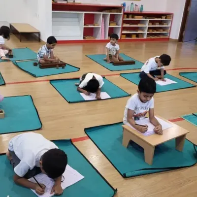 A snapshot of our classroom where children are absorbed in their work. Each child has their own mat and materials, fostering concentration and respect for each other's space.