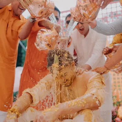 The groom gets a celebratory drenching during a fun-filled Haldi ceremony, a moment of pure, unscripted chaos and joy.
