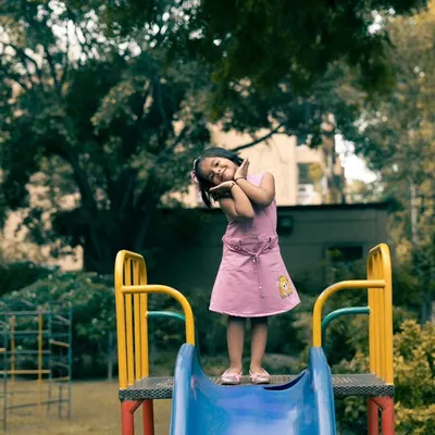 A full-of-life shot of my niece at the top of a slide in the park. I love capturing these playful, unposed moments that truly reflect a child's personality.