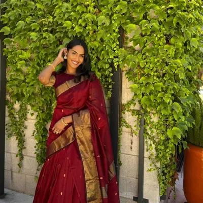 A happy client, Rishika from the USA, looking stunning in our viral maroon half saree. A testament to our global reach and personalized service.