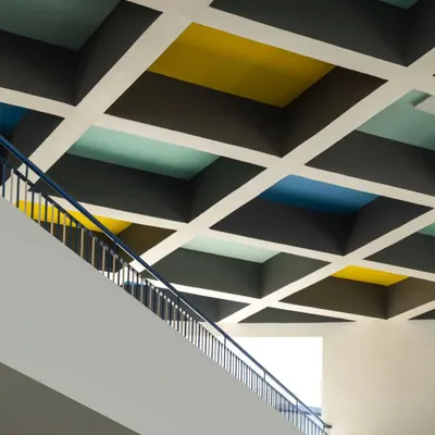 A colorful, coffered ceiling in a school designed by MySpace Architects adds a playful and stimulating element to the educational environment.