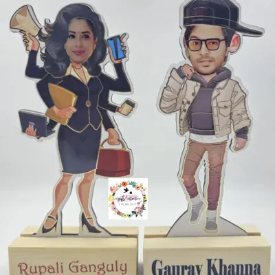 A pair of custom caricatures on wooden stands, featuring the actors from the show 'Anupama'. We can create these based on any photo.