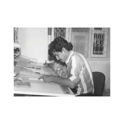 An archival photograph of our founder at the drafting table. This image represents the passion and dedication to the craft of architecture that has been the cornerstone of our practice since its inception.