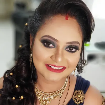 This reception look was all about drama and elegance. I created a bold smokey eye with a pop of gold and paired it with a classic red lip. The messy bun hairstyle with delicate hair accessories added a touch of modern romance.