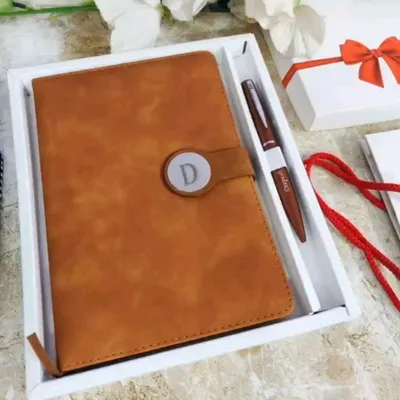 This is my premium diary and pen combo in a warm Camel Brown faux leather. The diary features a magnetic clasp with a custom initial, and it comes with a matching personalized pen in a white gift box.