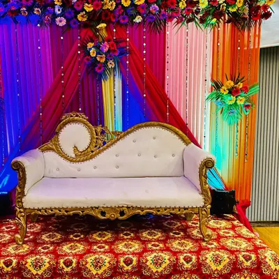 Here is the same wedding stage setup viewed with colorful event lighting. The blue and red spotlights completely change the mood for a reception party, making the flower arrangements and drapes stand out.