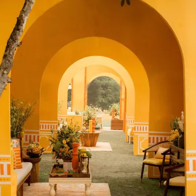 For the 'Kesar Sehar' Haldi, I wanted to celebrate the beauty of Indian heritage. I used a vibrant yellow and orange palette and created a corridor of arches, giving the space architectural depth and a feeling of walking through a modern Indian palace.