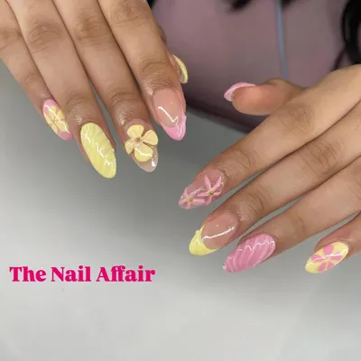A sweet and summery set featuring a mix of yellow and pink nails, adorned with hand-sculpted 3D flowers and textured details.