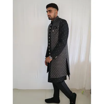 This outfit showcases a modern, layered approach to ethnic wear. A stylish grey printed long jacket is worn over a classic black kurta, creating a sharp and contemporary look perfect for any wedding function.