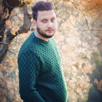 A candid-style male portrait taken outdoors with beautiful backlighting. This type of shot is great for a professional portfolio or social media, conveying a natural and confident look.