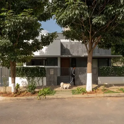 The front entrance of the DUBEY Home, designed to be pet-friendly and integrated with the neighborhood. The use of local slate stone on the facade and steps grounds the modern structure in its context.