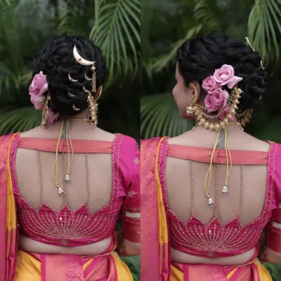 A beautiful bridal updo adorned with fresh pink roses and a traditional hair accessory, perfectly complementing the blouse design.