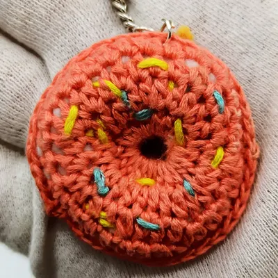 A donut a day keeps the sadness away! This is a close-up of my crochet donut keychain, showing the textured 'glaze' and colorful yarn 'sprinkles'. It's a sweet treat that lasts forever.