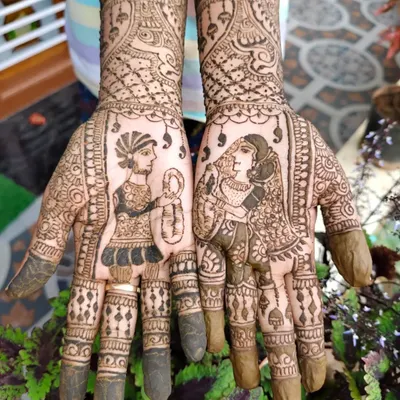A close-up of custom bride and groom portraits on the palms. This is a popular choice for brides who want their mehendi to be a true reflection of their wedding.