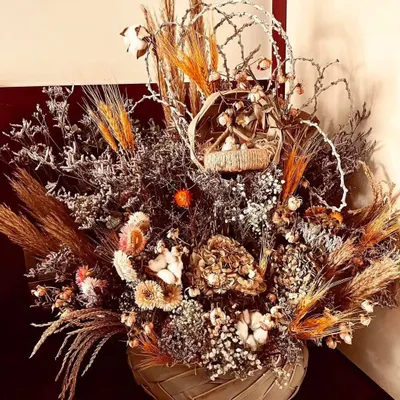A rustic and elaborate dried flower arrangement. This piece combines various dried grasses, wheat stalks, cotton flowers, and other preserved botanicals to create a long-lasting decorative bouquet with natural, earthy tones.