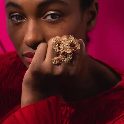 A model wearing my show-stopping cherry blossom ring. This piece is a sculpture for the hand, with branches of 18k gold flowers and ruby "cherries" wrapping around multiple fingers, inspired by the beauty of spring.