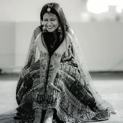 A happy bride, a beautiful design. This black and white shot perfectly captures the joy and elegance of the mehndi ceremony.