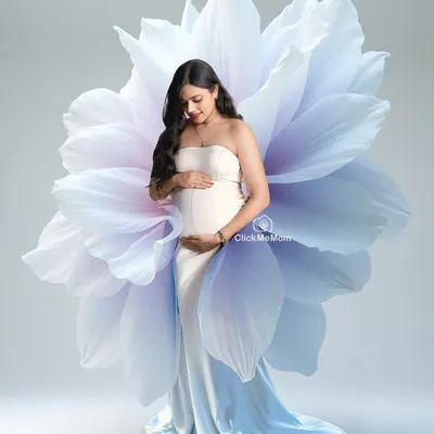 Blooming with life. In this artistic portrait, the mom-to-be emerges from a giant, ethereal flower, symbolizing the beauty and miracle of creation. It's a unique and conceptual maternity photo.