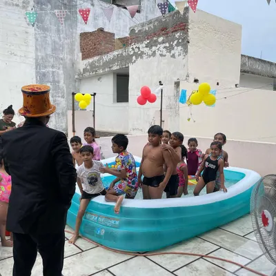Organizing a fun pool party on a rooftop. I'm here as the magician, ready to perform some water-themed tricks for the kids.