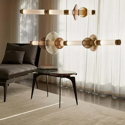 The Luna series by Gabriel Scott, configured as two horizontal pendants. The design stacks various blown glass shapes onto a linear frame, referencing the moon's diffused light and soft glow.