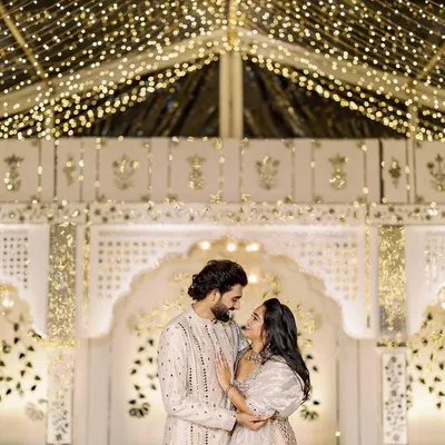 A stunning sangeet celebration for a beautiful couple, set against our custom-designed Thikri mirror work stage. The entire venue glows under a transparent tent strung with thousands of lights, creating an ethereal, starry night effect.
