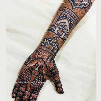 A celebration of peacocks. This design features pairs of peacocks on the palm, symbolizing love and beauty, with a traditional kalash on the arm for prosperity.