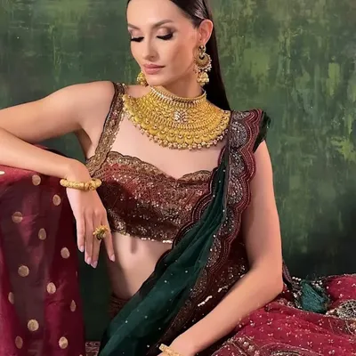 A stunning campaign shot featuring a modern take on a traditional look. The makeup is clean and sharp, with a focus on sculpted features and flawless skin.