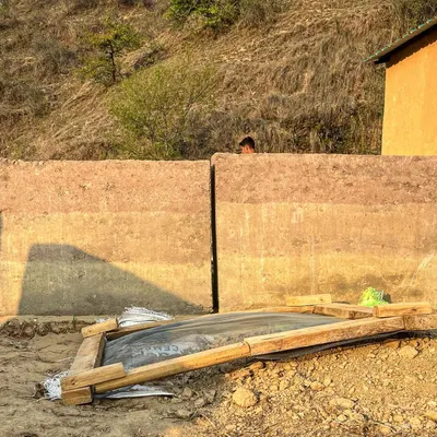The beautiful, layered tones of a rammed earth wall under construction in Almora. This ancient building technique uses locally sourced soil to create walls that are both structurally sound and aesthetically connected to the land.